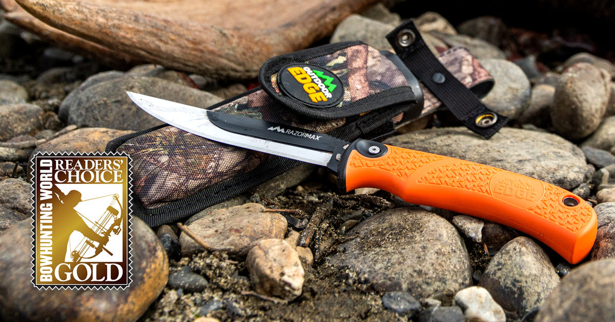 The Outdoor Edge RazorMax knife and its Mossy Oak sheath displayed on a bed of rocks next to the "Bowhunting World Reader's Choice Gold" award seal