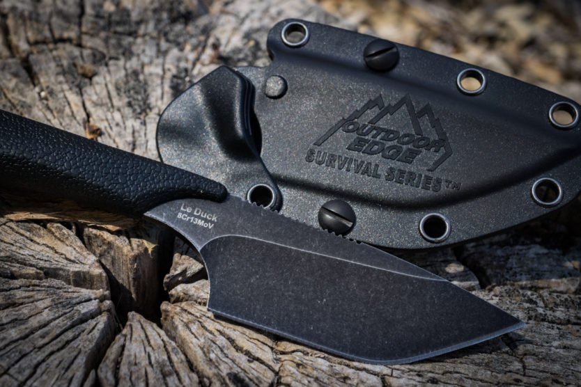 An action shot of a fisherman on a boat, holding up a large octopus as its tentacles splash in the water.