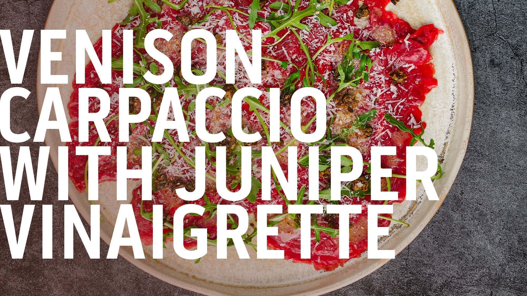 A plate of thinly sliced venison carpaccio with a juniper vinaigrette