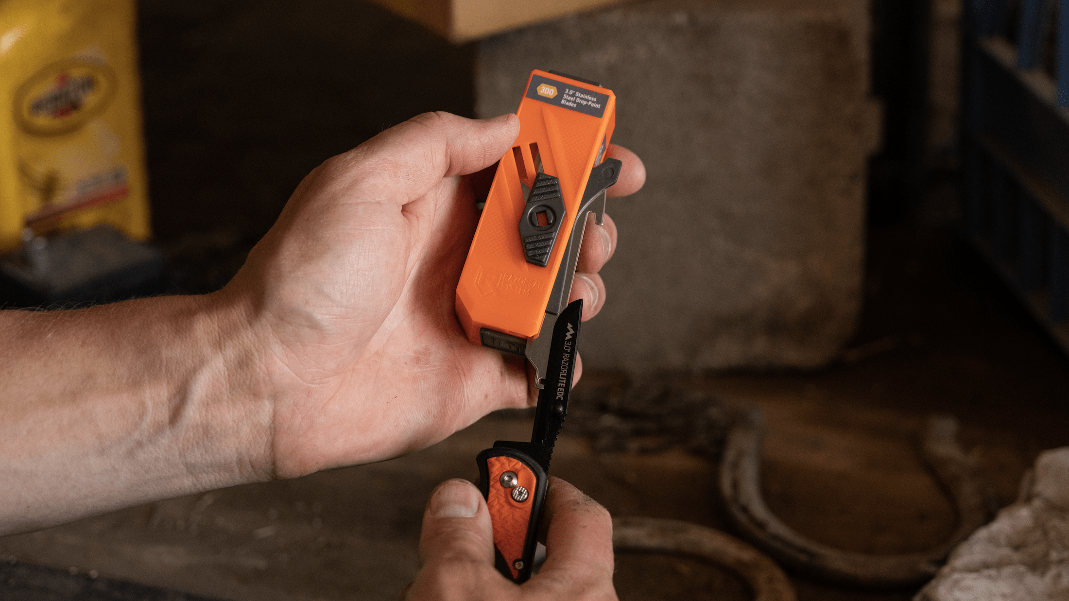 The knife is black and orange, and the blade is folded open.