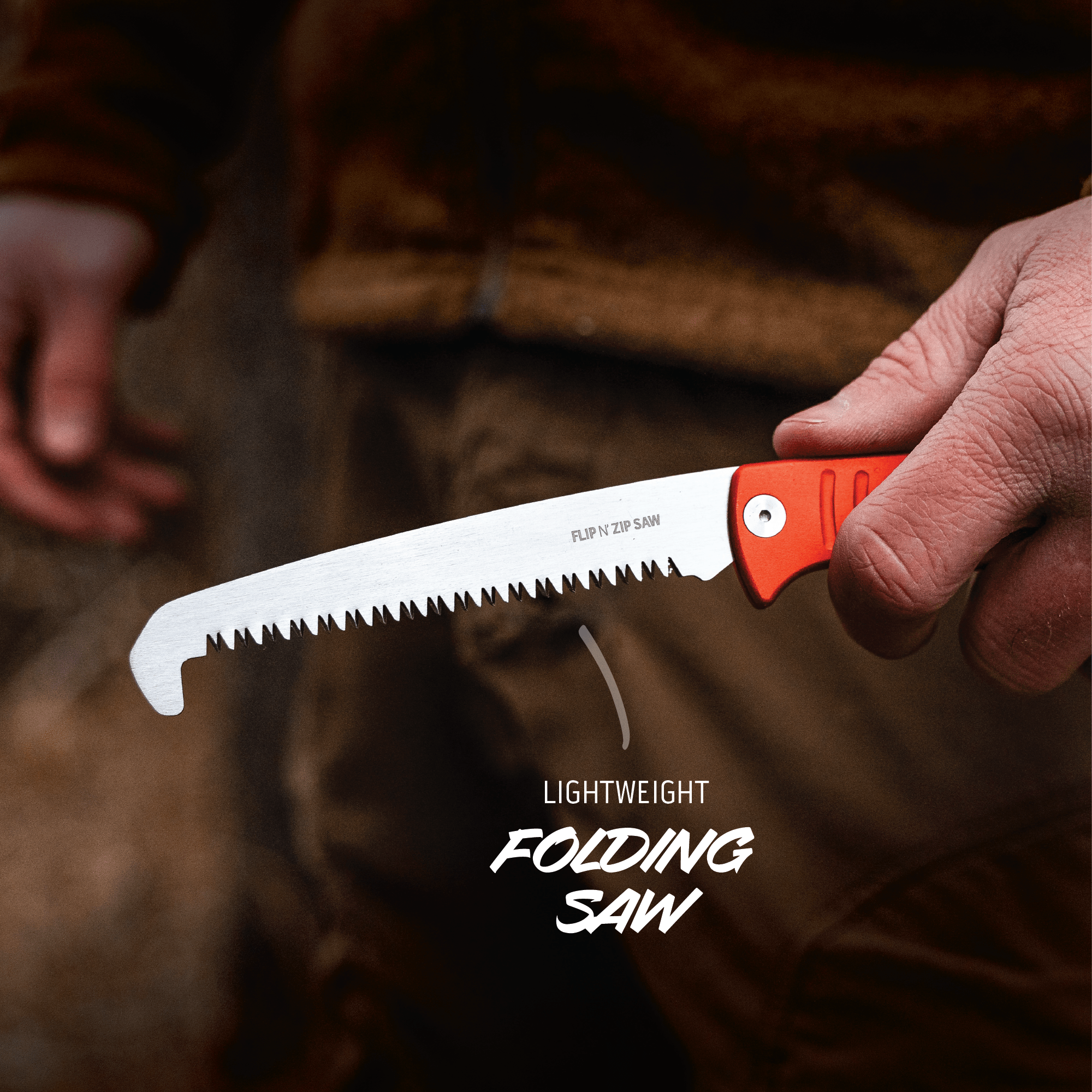 Hand holding a lightweight folding saw with a blurred background