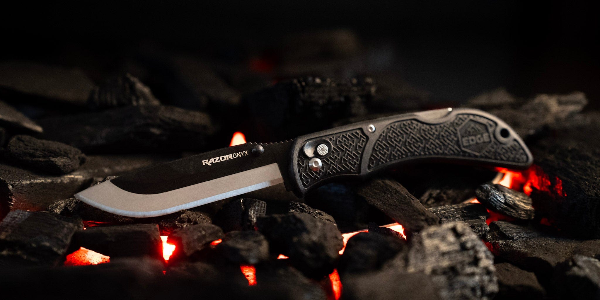 "The full Onyx EDC knife shown open on a bed of hot coals."