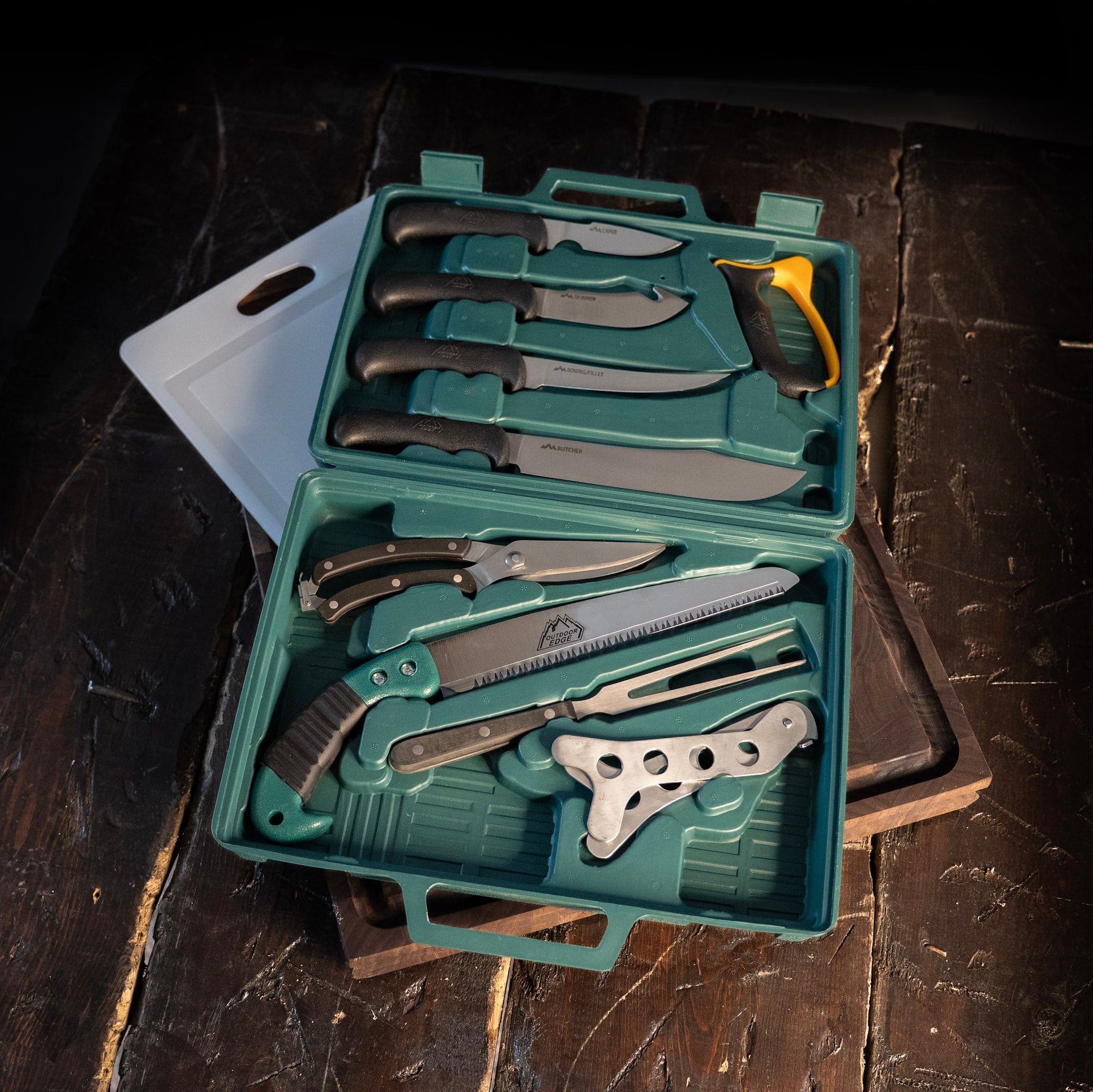 Set of knives and tools in a green case on a wooden surface