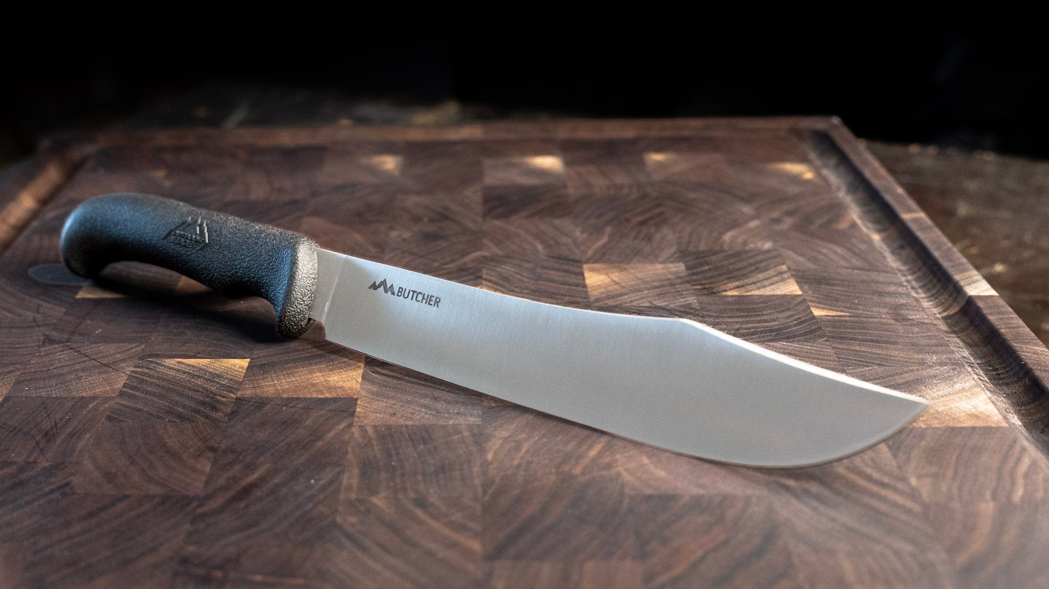 Knife with a black handle on a wooden cutting board