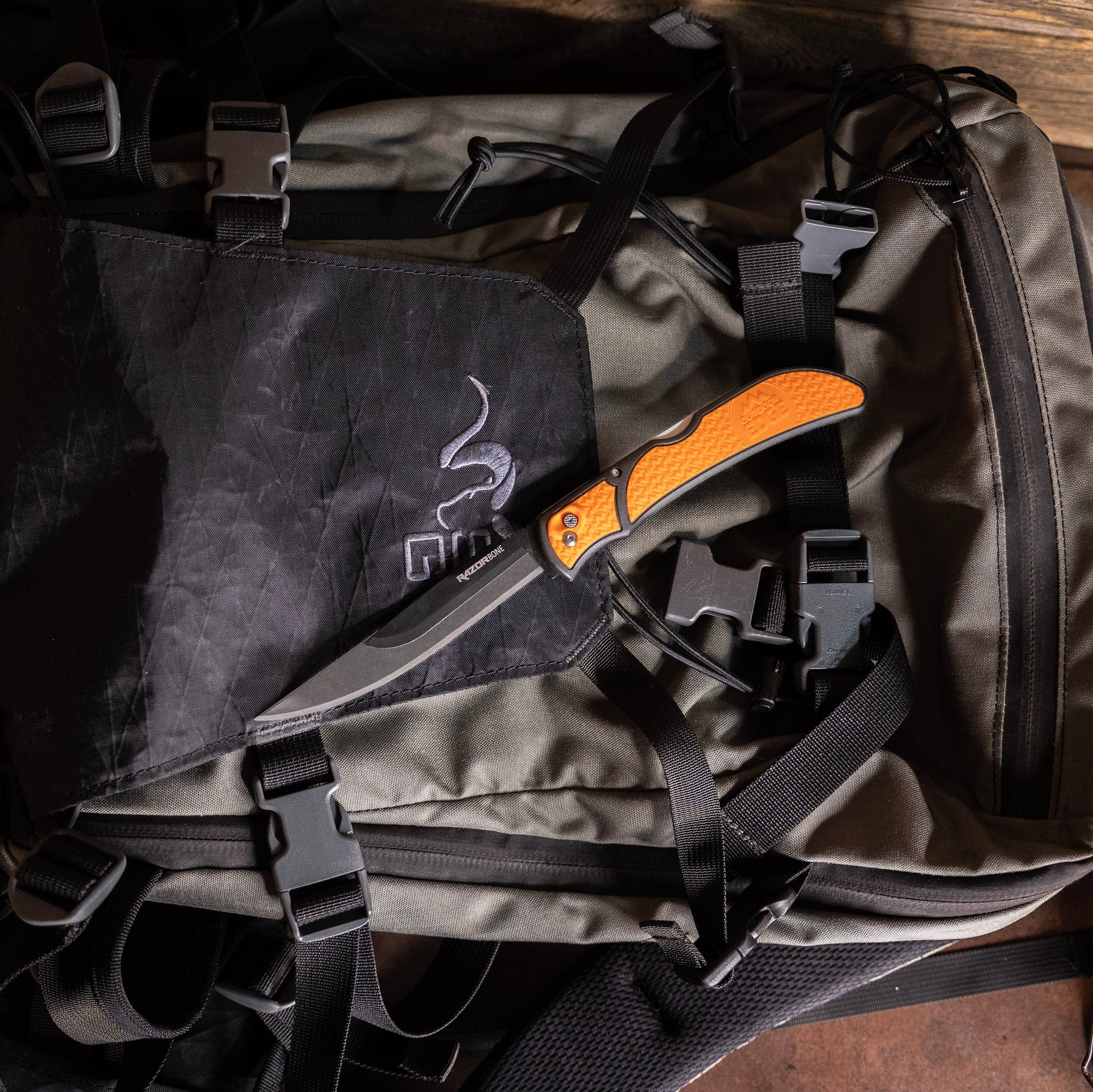 Knife with orange handle on a tactical backpack