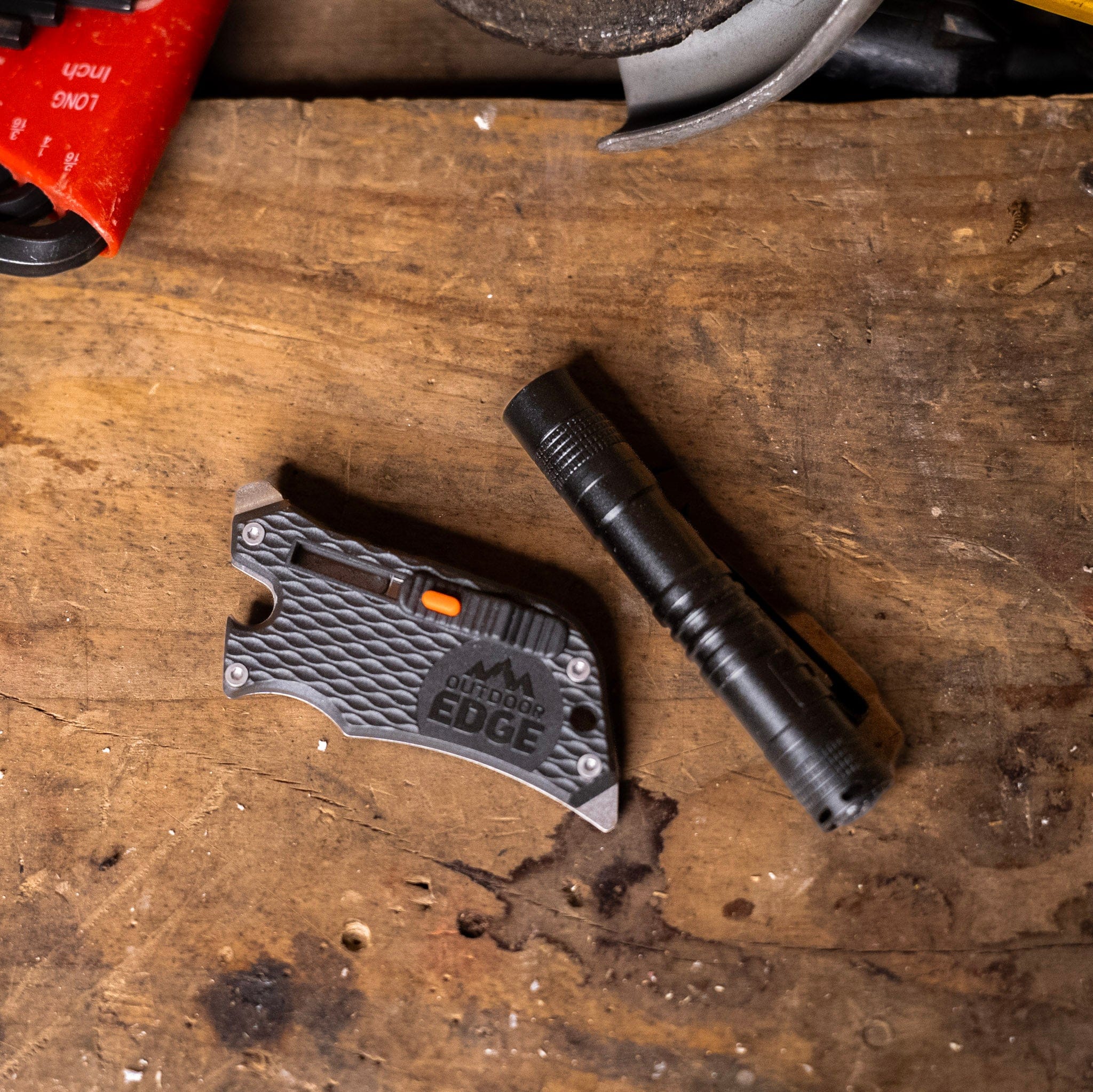Multitool and flashlight on a wooden surface