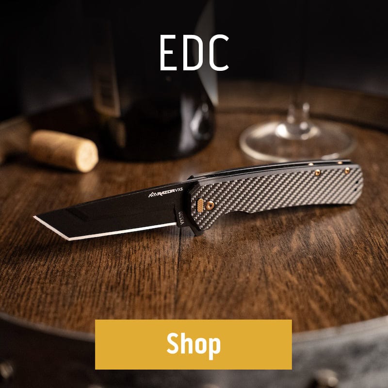 EDC folding knife with carbon fiber handle on a wooden table, with wine bottle and glass in background.