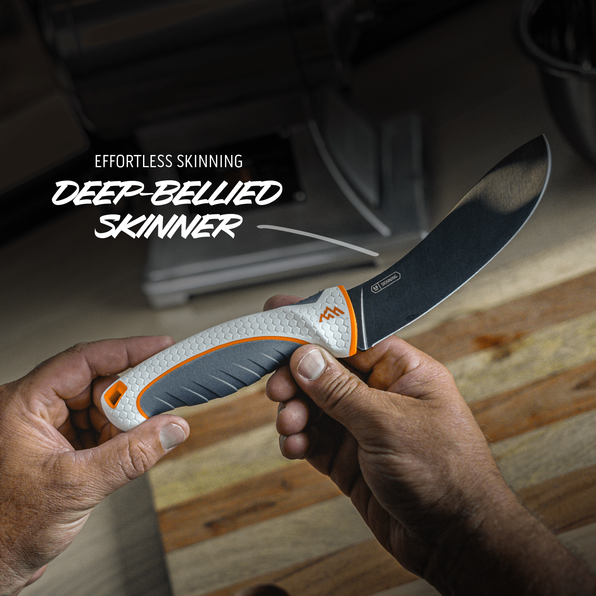 Hand holding a knife with text 'Effortless Skinning Deep-Bellied Skinner' on a wooden surface.