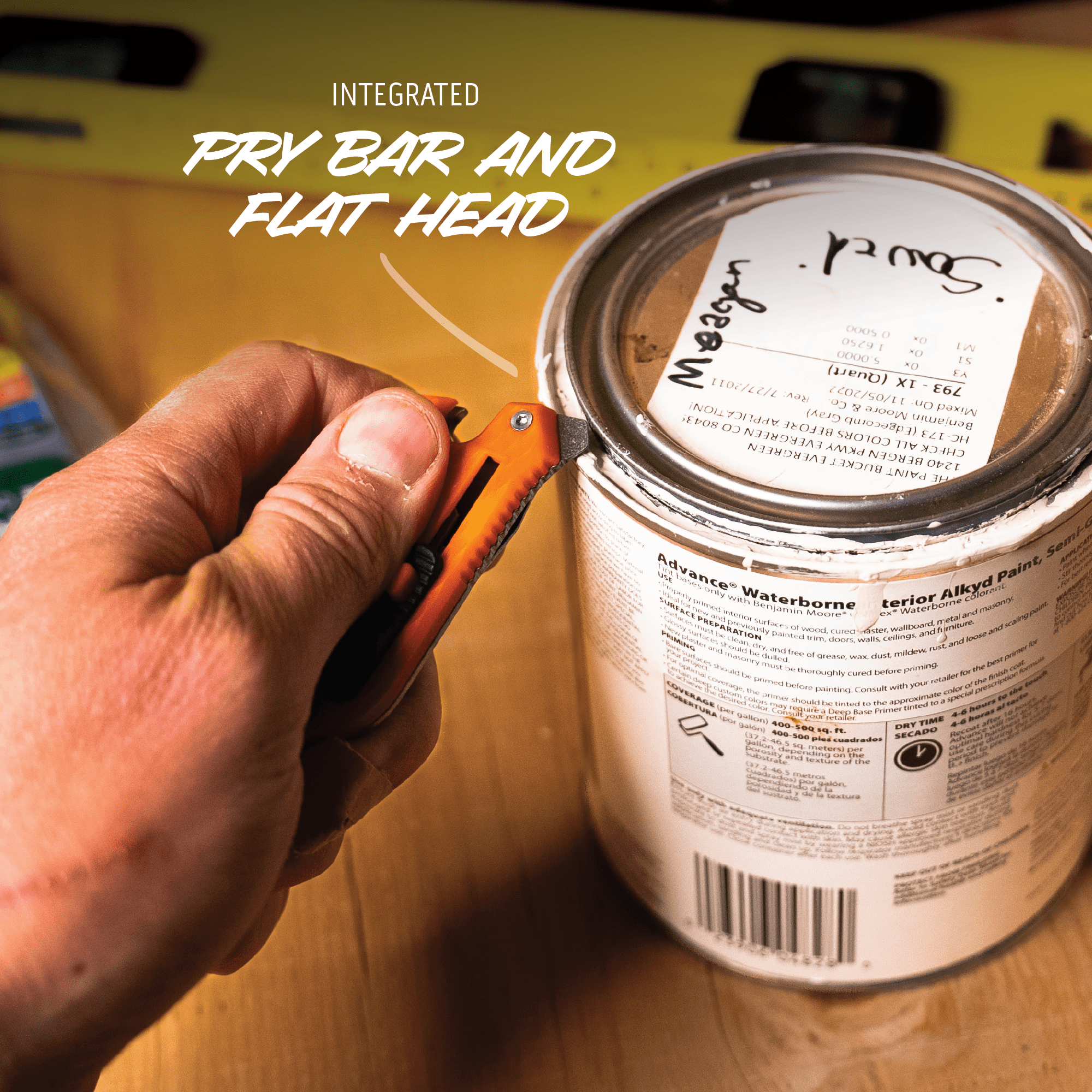Hand using a paint can opener on a can of Behr paint with text overlay.