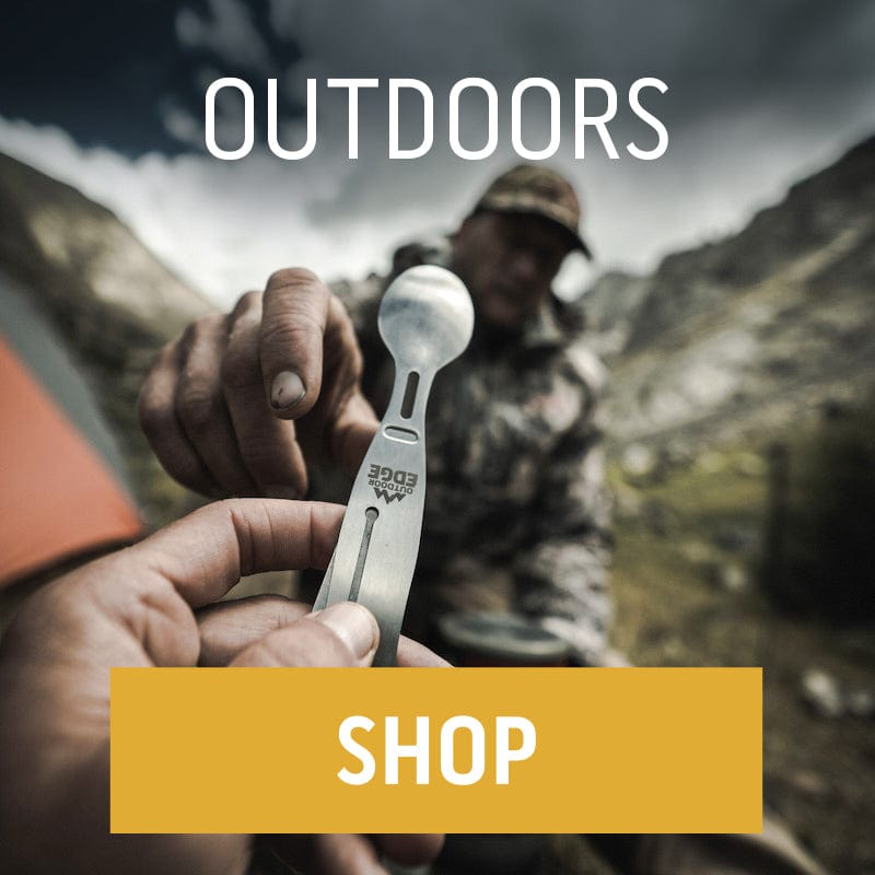 A first-person view of someone holding an Outdoor Edge ChowLite multi-tool utensil, with another person in camouflage in the background in a mountain setting. "