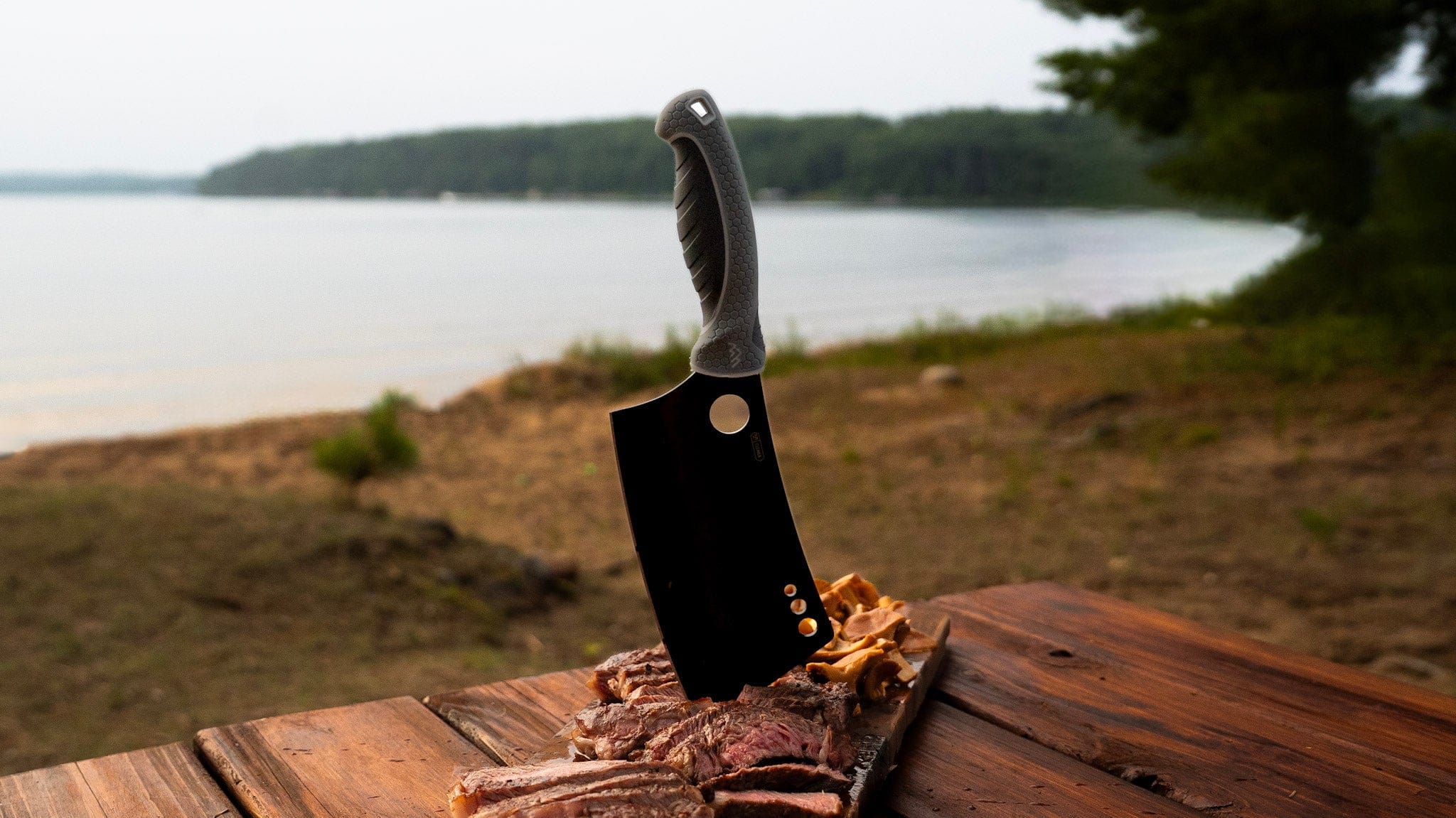 Knife with a wooden handle on a wooden surface near a body of water