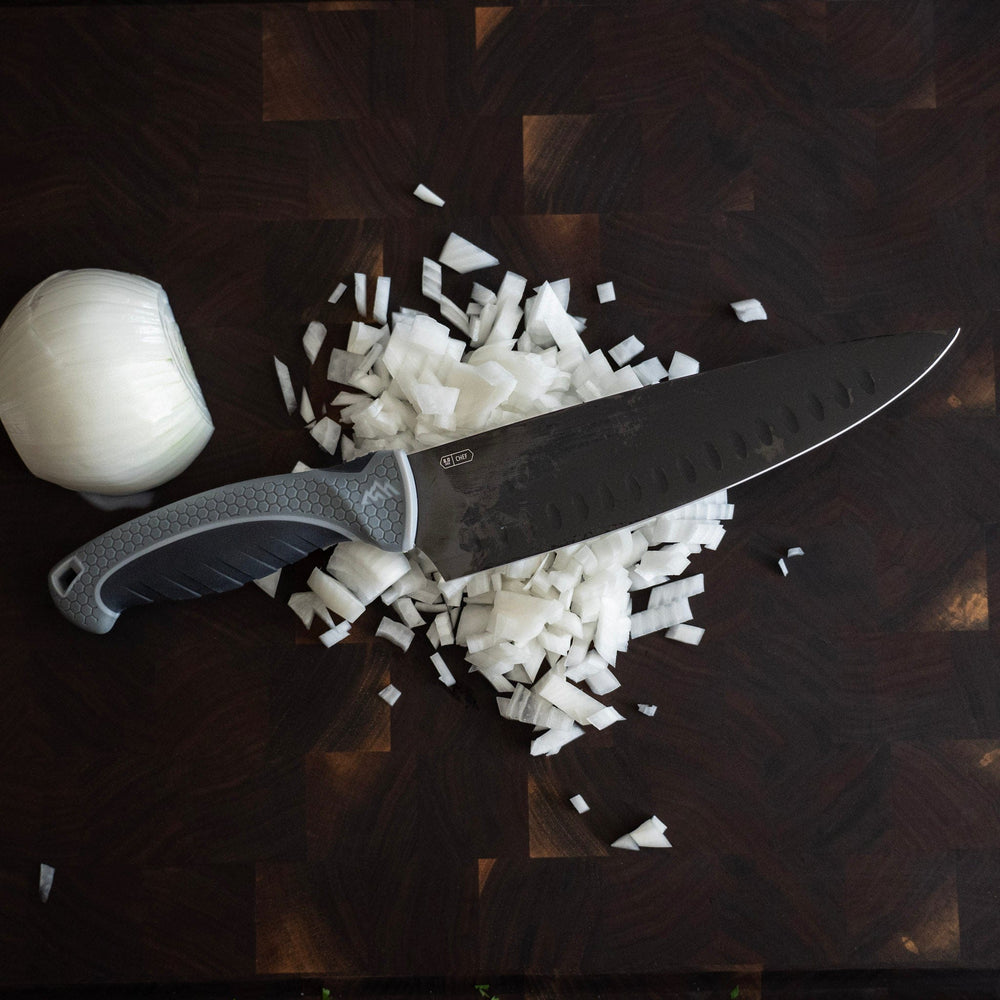 Knife with chopped onions on a wooden cutting board