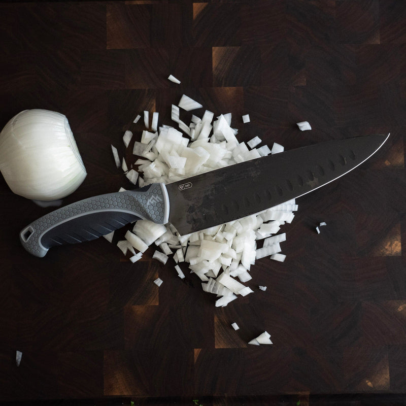 Knife with chopped onions on a wooden cutting board