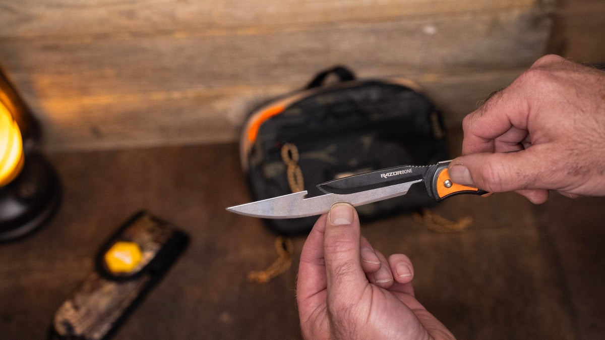 Person holding a knife with a blurred background of a wooden surface and tools.