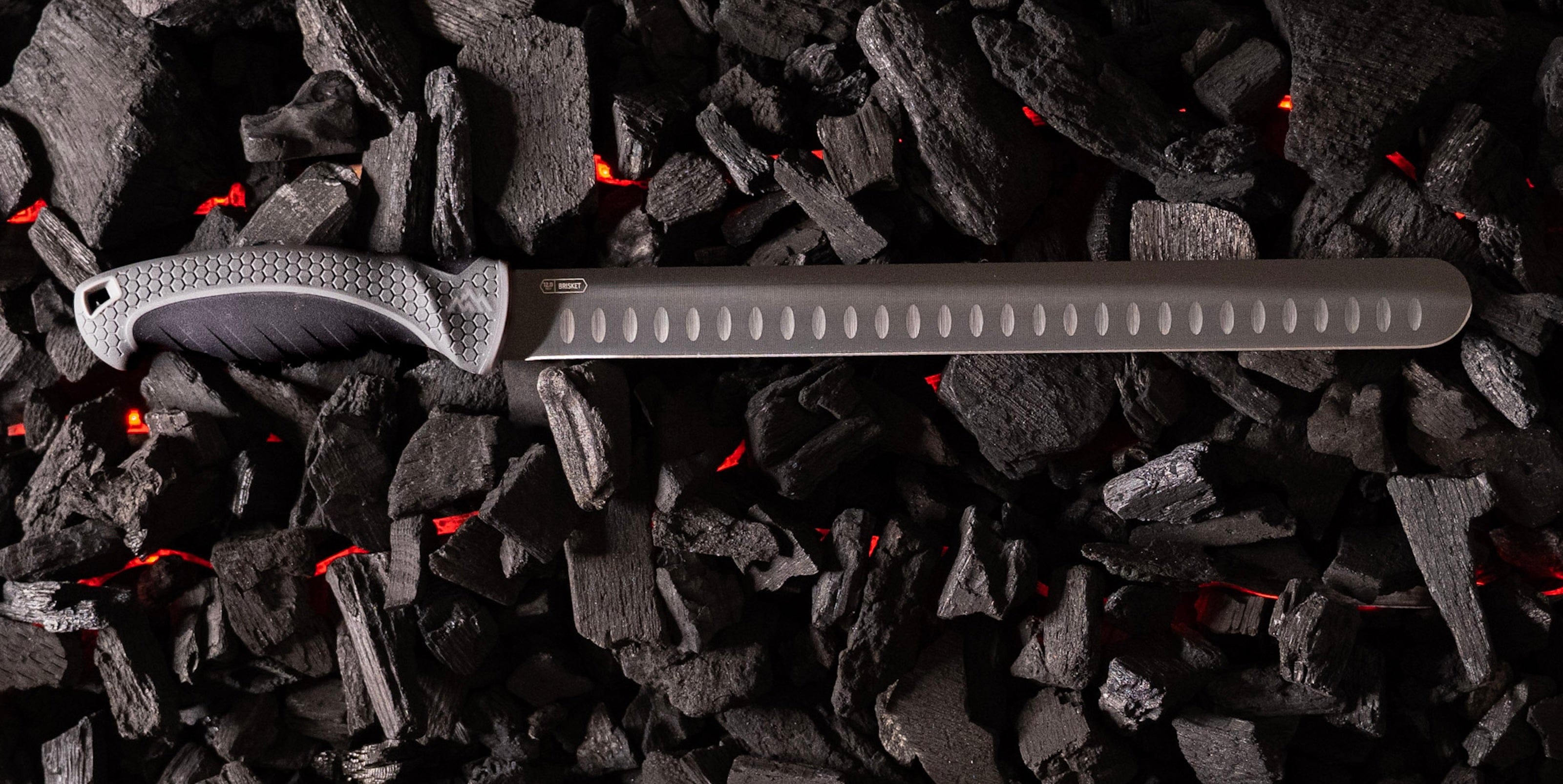 Knife with a textured handle on a bed of dark stones