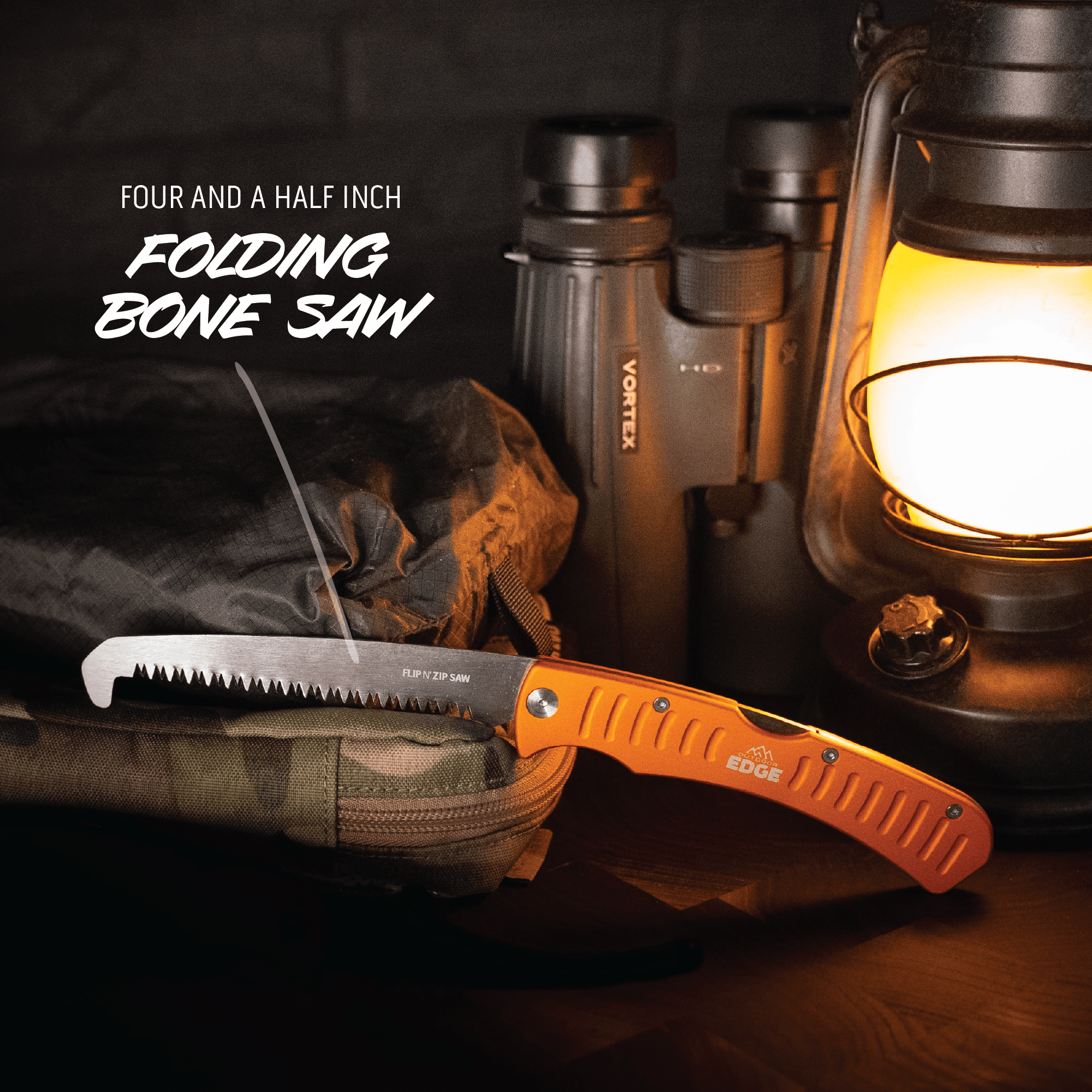 Folding bone saw with orange handle on a dark background with lantern and binoculars.