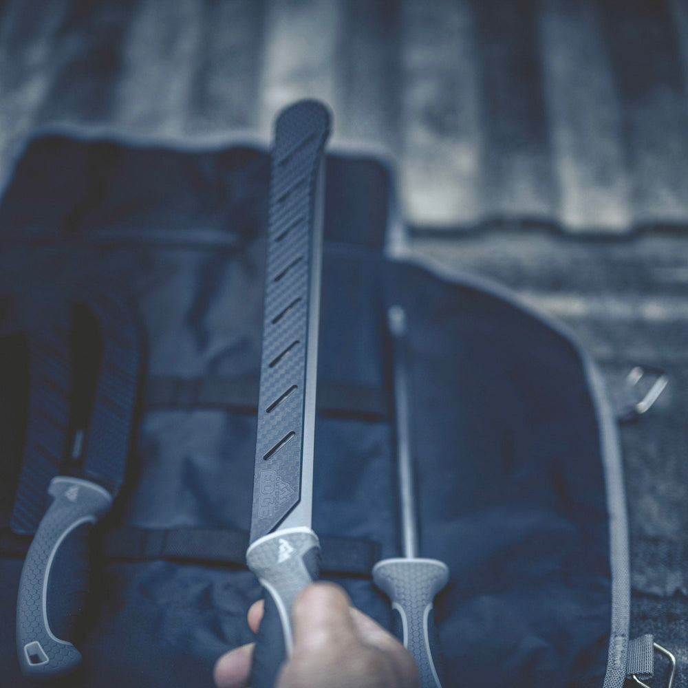 Person holding a large knife with a textured handle against a blurred background