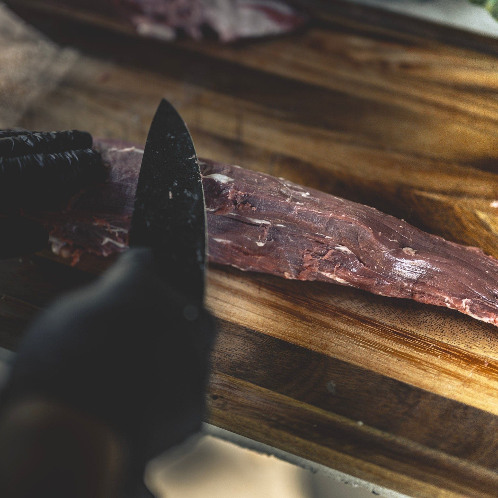 Knife on a wooden cutting board with a blurred background